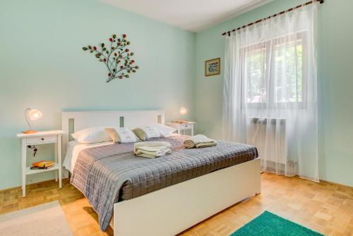 a bedroom with a bed and a window at Newly refreshed property JOVI-relaxing, fenced, private, heated pool & view in Tugare