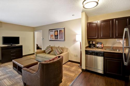 a living room with a couch and a kitchen at Staybridge Suites Grand Rapids-Kentwood by IHG in Grand Rapids