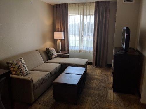 a living room with a couch and a tv at Staybridge Suites Grand Rapids-Kentwood by IHG in Grand Rapids