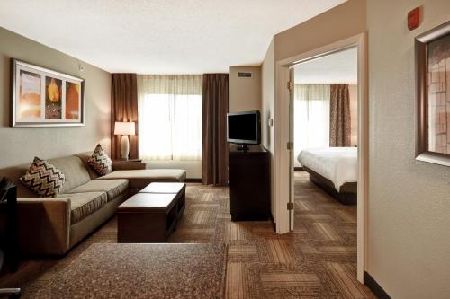 a hotel room with a couch and a bed at Staybridge Suites Grand Rapids-Kentwood by IHG in Grand Rapids