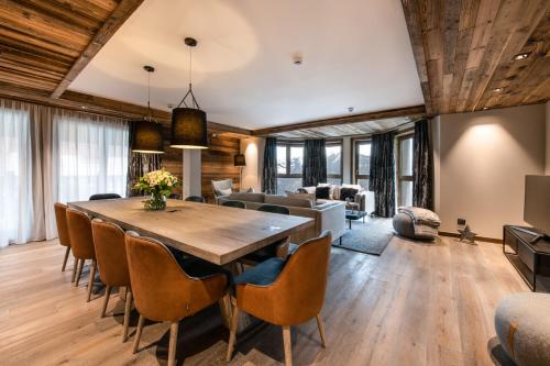 a dining room with a large wooden table and chairs at Manali Lodge by Alpine Resorts in Courchevel