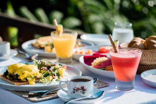 a table topped with plates of food and drinks at Ubud Valley Boutique Resort in Ubud