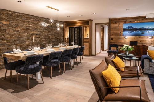 a dining room with a long table and chairs at Manali Lodge by Alpine Resorts in Courchevel