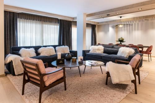 a living room with a blue couch and chairs at Manali Lodge by Alpine Resorts in Courchevel
