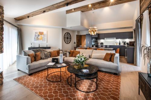 a living room with a couch and a table at Manali Lodge by Alpine Resorts in Courchevel