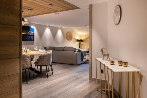 a living room with a table and a couch at Manali Lodge by Alpine Resorts in Courchevel