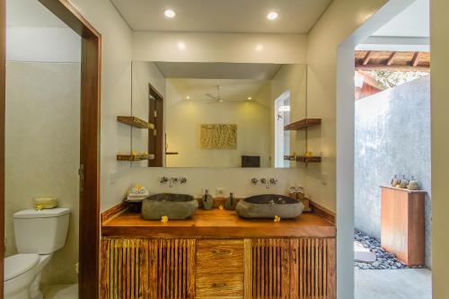 a bathroom with two sinks and a mirror at Villa Beji Mawang Ubud by GenuineHost in Ubud