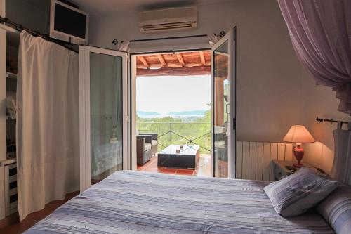 ein Schlafzimmer mit einem Bett und einer Glasschiebetür in der Unterkunft Casa Capricho by Eivillas in Sant Jordi