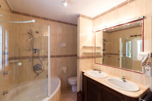 ein Badezimmer mit Badewanne, Waschbecken und Dusche in der Unterkunft Casa Capricho by Eivillas in Sant Jordi