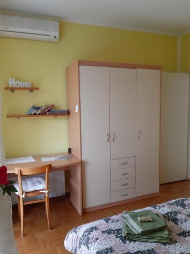 a bedroom with a desk and a bed at Apartments and Rooms Knez in Portorož