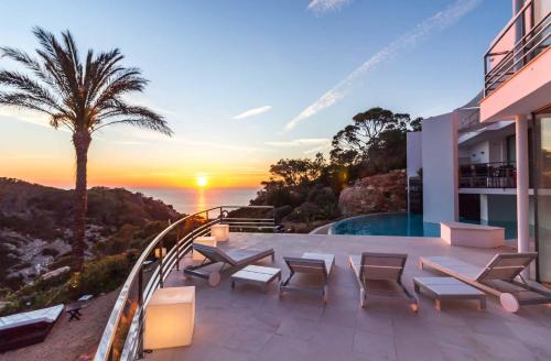 a house with a balcony with a view of the ocean at VILLA VADELLA in Cala Vadella