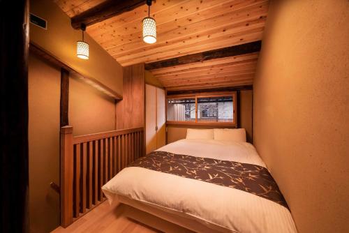 a small bedroom with a bed in a room at Kanade Matsubaragokomachi-Momijittei in Kyoto