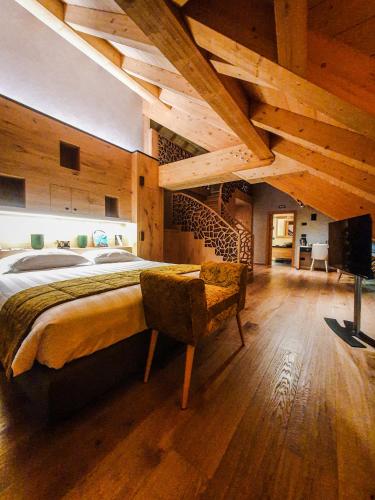 a bedroom with a large bed and wooden ceilings at Asiago Sporting Hotel & Spa in Asiago