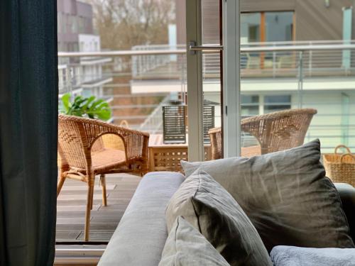 a couch sitting on a porch with a view of a balcony at Nature&Eco Apartament in Międzyzdroje