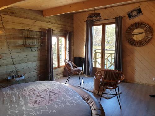 um quarto com uma cama num quarto com paredes de madeira em Etangs du Moulin em Suzy