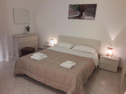 マルサラにあるGuest House Porto Marsalaのベッドルーム1室(大型ベッド1台、タオル2枚付)