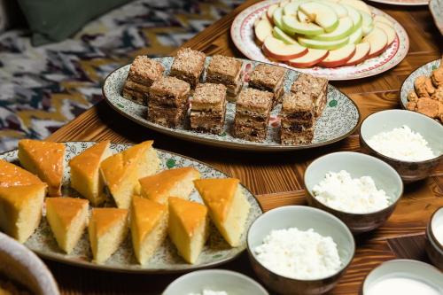 a table topped with plates of food and desserts at Grand Sapphire Hotel in Almaty