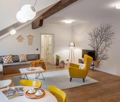 a living room with yellow chairs and a couch at 4 Trees Apartments by Adrez Living in Prague