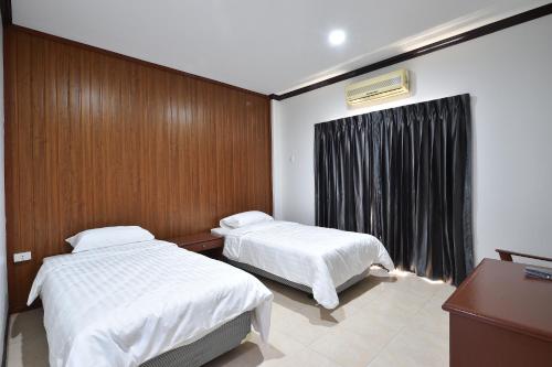 AT TP HOTEL في بيتشابون: غرفة فندقية بسريرين ونافذة