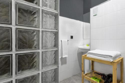 baño con pared de cristal y aseo en Hotel San Miguel en Gijón