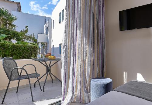 una camera da letto con balcone, tavolo e TV di Castello Village Resort a Sissi