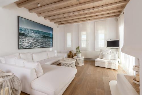 een witte woonkamer met witte meubels en een televisie bij Margi Villas in Mykonos-stad