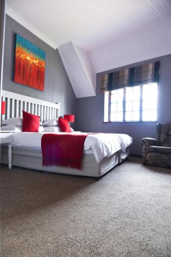 a bedroom with a large white bed with red pillows at Constantia Hotel and Conference Centre in Midrand