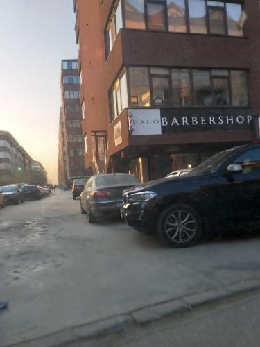 a street with cars parked in front of a barber shop at Luxury Daniel Apartament Residence Militari in Roşu