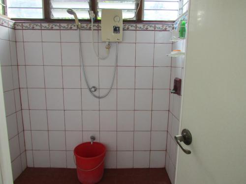 a bathroom with a red bucket and a shower at Felipa Beach and Guesthouse - Lotus in Dumaguete