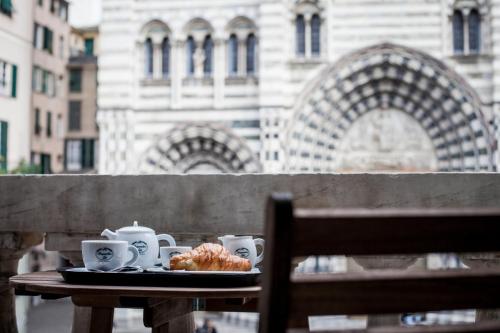 a table with a plate of food and cups on it at Residenza Bendinelli-Sauli in Genova
