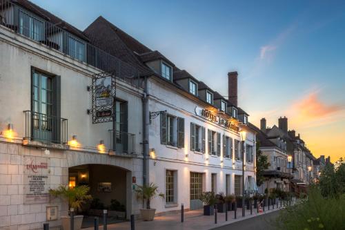 een groot wit gebouw met verlichting op een straat bij Hôtel Le Maxime - Best Western Signature Collection in Auxerre