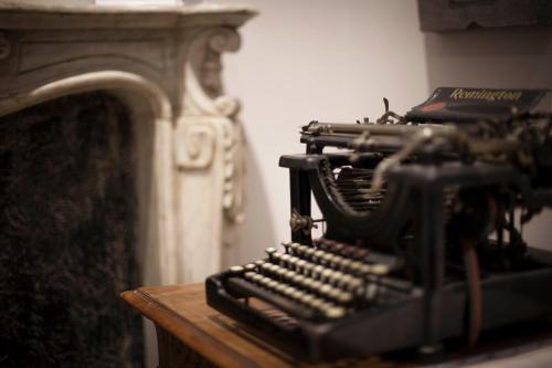 an old typewriter sitting on a table next to a fireplace at Residenza Bendinelli-Sauli in Genova