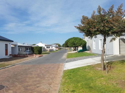 an empty street in a residential neighborhood with houses at Pearly Waves in Pearly Beach