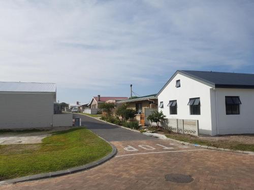 a white house with a stop sign in a driveway at Pearly Waves in Pearly Beach