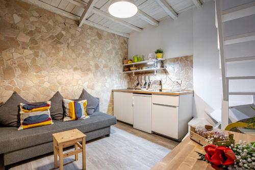 a living room with a couch and a kitchen at Giudecca Apartments in Syracuse