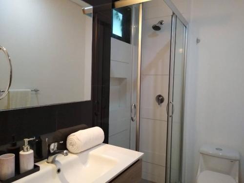 ein Badezimmer mit einem weißen Waschbecken und einer Dusche in der Unterkunft Studio close to 5th Av, with Amazing Roof Pool View, Gym, Spa and more in Playa del Carmen