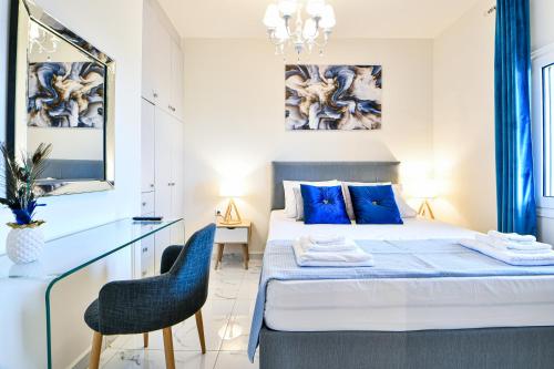 1 dormitorio con 1 cama, escritorio y sillas en Koukounari Luxury Apartments, en Vathí