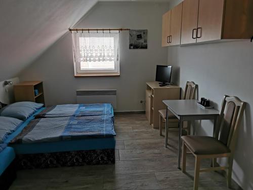 Habitación pequeña con cama y mesa en Restaurace a penzion u Jessyho, en Perná