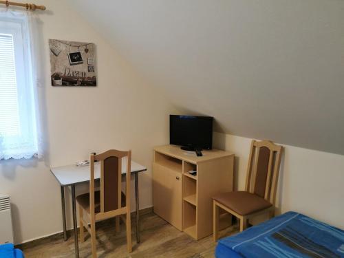 Habitación pequeña con mesa pequeña y TV. en Restaurace a penzion u Jessyho, en Perná
