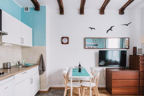 Una cocina con una mesa y sillas en una habitación. en Sopot Host Molo, en Sopot