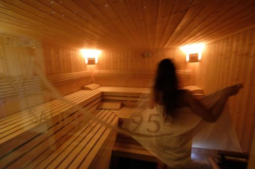 a woman is standing in a sauna at Cimon Dolomites Hotel in Predazzo
