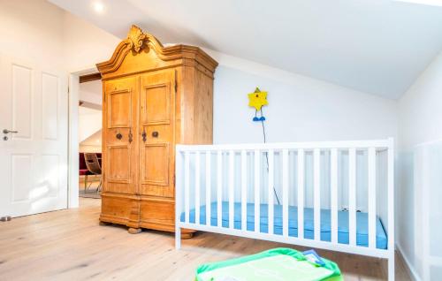 a room with a crib and a wooden cabinet at Ferienwohnung Biobauernhof Peter Anderl Hof in Pfreimd