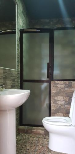 a bathroom with a white toilet and a sink at MJ's Residences Garden Hotel in Moalboal