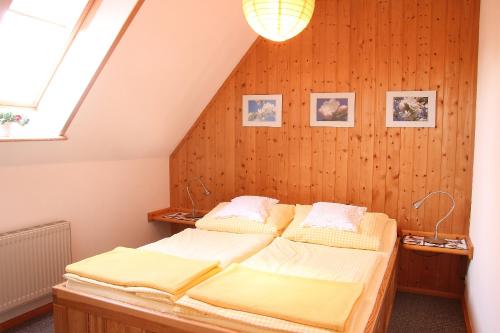 - 2 lits dans une chambre dotée de murs en bois dans l'établissement Ferienwohnungen im Altbauernhaus, à Hohendorf