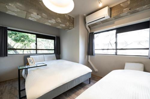 a bedroom with two beds and two windows at Eims stay Oomori206 in Tokyo