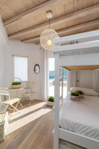 a bedroom with a bed and a desk in a room at Margi Villas in Mikonos