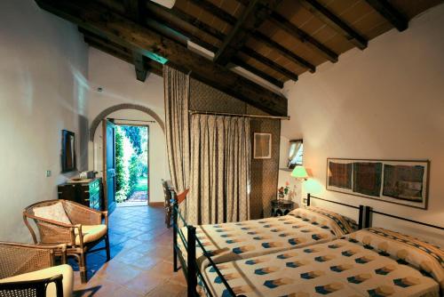 a bedroom with a bed and a chair and a window at Poggetto Masino in Suvereto