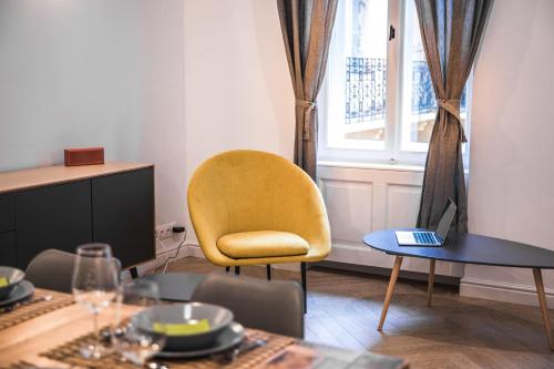 a dining room with a yellow chair and a table at IRANYI Home - flat in the heart of downtown in Budapest