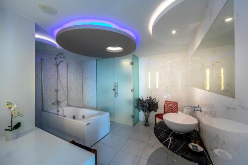 a bathroom with a tub and a sink at Melissi Beach Hotel & Spa in Ayia Napa