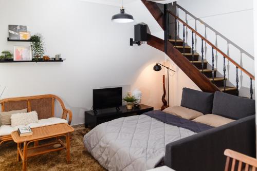 a living room with a bed and a staircase at Velis apartment Thessaloniki in Thessaloniki